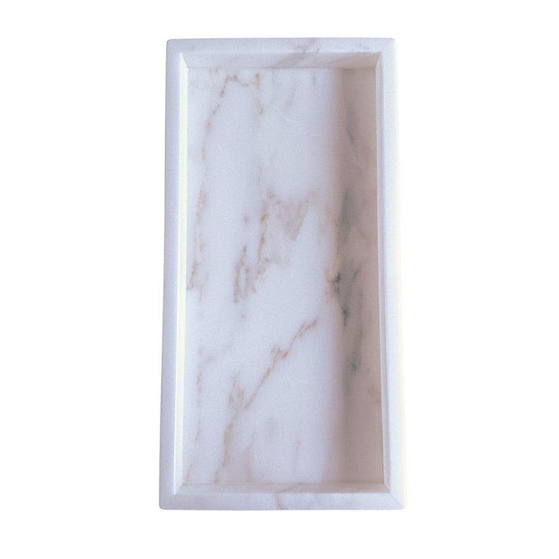 Close-up of a handmade natural marble rectangle tray showing the smooth polished surface, raised edges, and the subtle organic veining that makes each piece one of a kind.