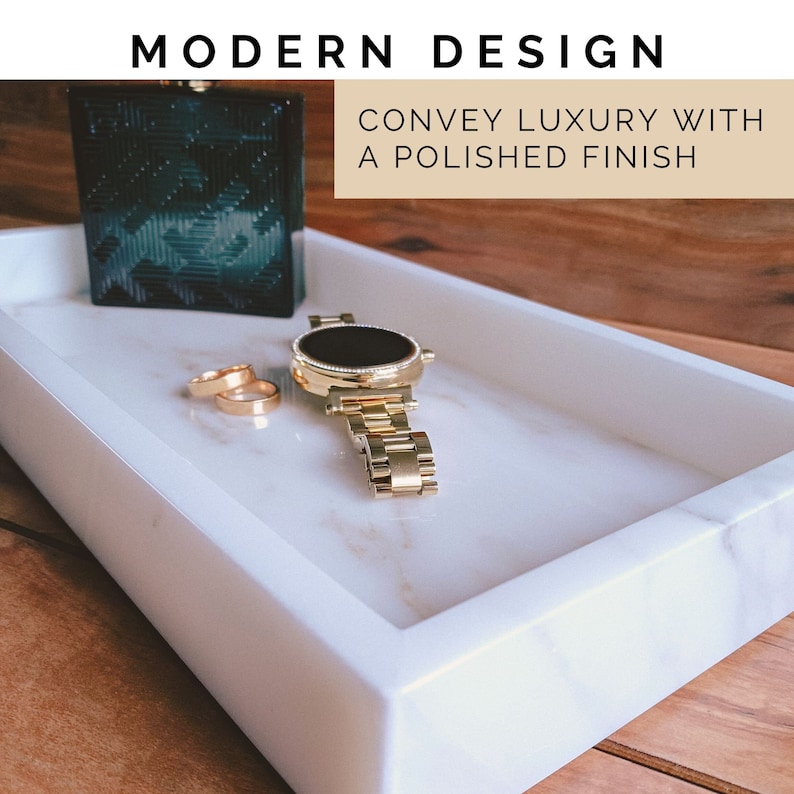 Polished Calacatta Gold marble bathroom tray holding a gold watch, rings, and a cologne bottle on a wooden surface, styled as a men's nightstand or bathroom counter organizer.