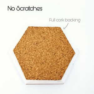 May include: Hexagon-shaped cork coaster with a white border. The coaster has a cork backing and the text "Full cork backing" is written on the image.