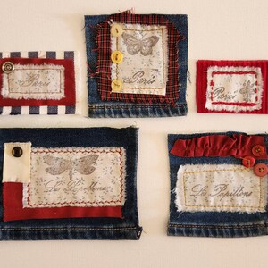May include: Five denim squares with red and white fabric accents. Each square features a different design, including a butterfly, a dragonfly, and the words "Paris" and "Les Papillons".