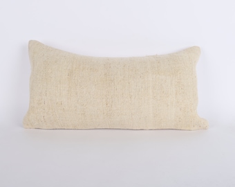 May include: A cream-colored rectangular pillow with a woven texture.