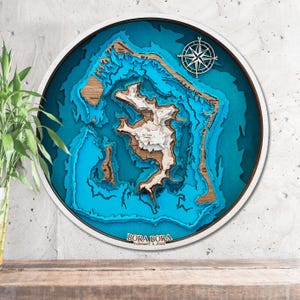 Könnte beinhalten: Eine blaue und braune Holzkarte von Bora Bora mit einer Kompassrose und dem Datum "3. Februar 2020".