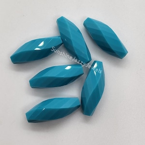 May include: Six turquoise faceted oval shaped beads. The beads are smooth and have a glossy finish.