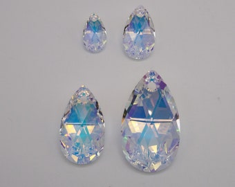May include: Four iridescent teardrop-shaped crystal pendants with a hole at the top for stringing. The crystals are clear with a rainbow effect.
