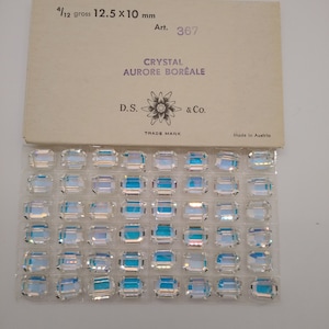 May include: A box of 12.5 x 10 mm crystal Aurora Borealis rhinestones, labeled "Crystal Aurore Boréale" and "D.S. & Co.", with a flower logo and "Trade Mark" text. The box is labeled "4/12 gross" and "Art. 367" and says "Made in Austria".