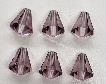 May include: Six purple crystal beads with a pointed tip and a faceted design. The beads are arranged in two rows of three.