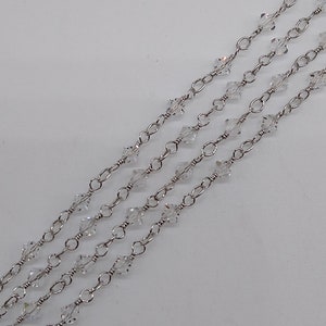 K&ouml;nnte beinhalten: Eine silberne Kette mit klaren Kristallperlen. Die Kette ist geschichtet und hat einen zarten Look.
