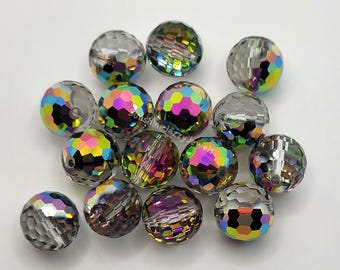 May include: A collection of iridescent glass beads with a faceted design. The beads are a mix of clear and rainbow colors.