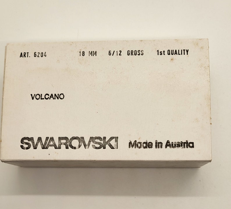 以下が含まれることがあります： 「ART. 6204」、「18 MM」、「6/12 GROSS」、「1st QUALITY」、「VOLCANO」、「SWAROVSKI」、「Made in Austria」と黒文字で書かれた白い箱。