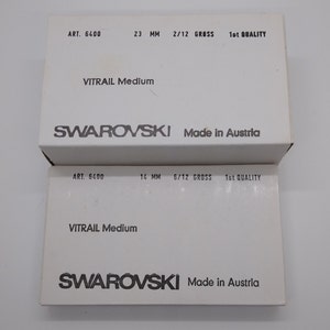 Puede incluir: Dos cajas blancas con texto negro. La caja superior dice "ART. 6400 23 MM 2/12 GROSS 1st QUALITY VITRAIL Medium SWAROVSKI Made in Austria". La caja inferior dice "ART. 6400 14 MM 6/12 GROSS 1st QUALITY VITRAIL Medium SWAROVSKI Made in Austria".