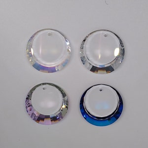May include: Four crystal suncatchers with a round shape and a hole at the top. Two are clear, one is iridescent purple, and one is iridescent blue.
