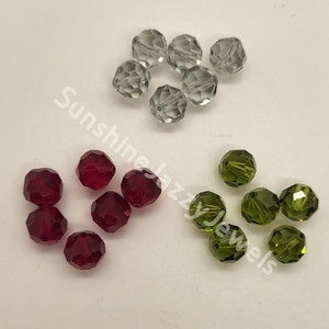 May include: Assortment of faceted glass beads in red, green, and clear colors. The beads are round and have a shiny finish.