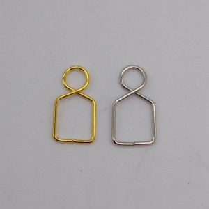 May include: Two metal jump rings, one gold and one silver, with a rectangular shape and a loop at the top.