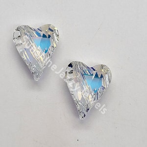 May include: Two clear crystal heart-shaped charms with a faceted design. The charms have a rainbow iridescent effect.