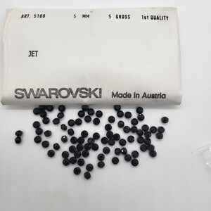 May include: A packet of 5 gross of 5 mm black jet Swarovski crystals. The packet is labelled "ART. 5100, 5 MM, 5 GROSS, 1st QUALITY, JET, SWAROVSKI, Made in Austria".