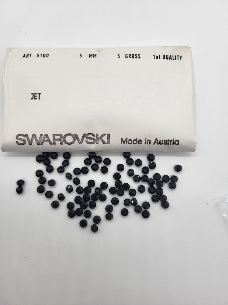 May include: A packet of 5 gross of 5 mm black jet Swarovski crystals. The packet is labelled "ART. 5100, 5 MM, 5 GROSS, 1st QUALITY, JET, SWAROVSKI, Made in Austria".