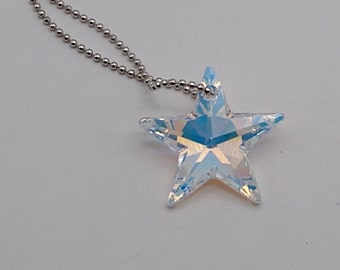 May include: A silver chain necklace with a clear iridescent star-shaped crystal pendant.