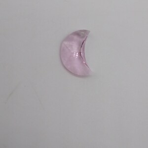 May include: A light pink crystal crescent moon charm with a hole at the top for hanging.