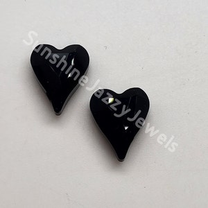 May include: Two black heart-shaped resin cabochons with a glittery, iridescent finish.