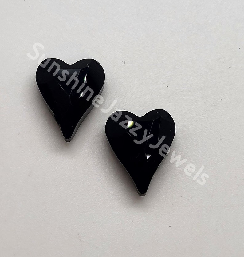 May include: Two black heart-shaped resin cabochons with a glittery, iridescent finish.