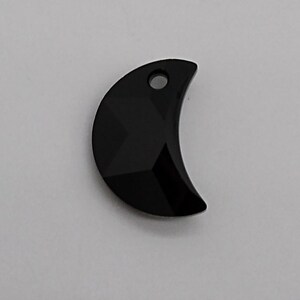 May include: Black crescent moon shaped crystal charm with a small hole at the top for hanging.