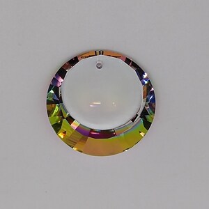 May include: A round, iridescent crystal prism with a hole in the top for hanging. The prism has a rainbow effect with shades of green, yellow, orange, red, purple, and blue.