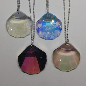 May include: Four iridescent crystal shell pendants on silver chains. The shells are in shades of blue, purple, and white.