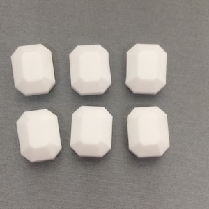 May include: Six white, octagonal-shaped buttons with a smooth, matte finish.