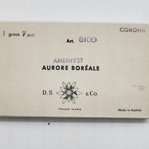 May include: A rectangular box with the text "CORONA" and "1 gross 7 mm." The box also features the text "Art. 5100," "AMETHYST AURORE BOR&Eacute;ALE," and "D.S. & Co. TRADE MARK Made in Austria."