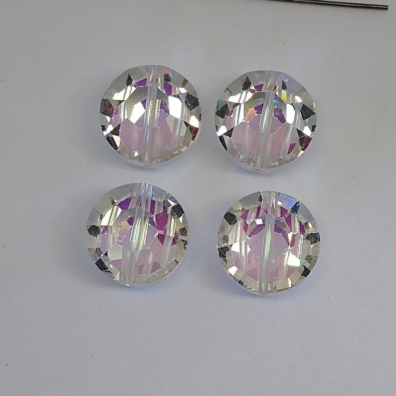 K&ouml;nnte beinhalten: Vier irisierende, klare Glasperlen mit facettiertem Design. Die Perlen haben einen Regenbogeneffekt und sind perfekt f&uuml;r die Schmuckherstellung.