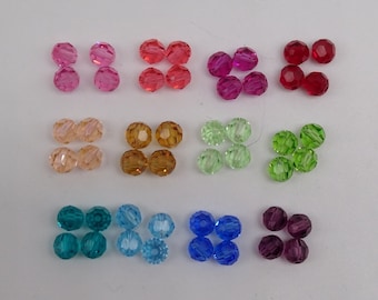 May include: Assortment of colorful glass beads in various colors, including red, pink, orange, green, blue, and purple. The beads are round and have a faceted design.