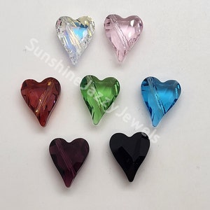 May include: Seven heart-shaped crystal beads in various colors, including clear, pink, red, green, blue, purple, and black. The beads have a faceted design and are approximately 1 inch in size.