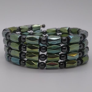 May include: A multi-strand bracelet made of green and blue faceted beads with black round beads interspersed throughout.