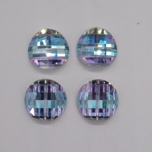 May include: Four iridescent glass beads with a blue and purple color gradient. The beads have a faceted design with a horizontal stripe pattern.