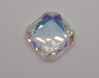 May include: A clear iridescent octagon-shaped crystal with a faceted design.