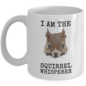 May include: White ceramic coffee mug with a black and white illustration of a squirrel and the text "I am the Squirrel Whisperer".