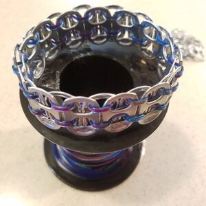 Peut inclure: Un bracelet argent&eacute; fait de languettes de canettes avec un cordon bleu et violet tiss&eacute; &agrave; travers les languettes.