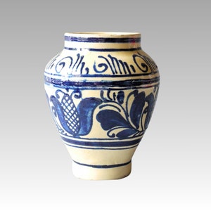 Könnte beinhalten: Eine weiße Keramikvase mit blauen Blumenmustern. Die Vase hat einen runden Körper und einen schmalen Hals.