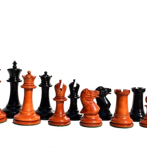 May include: A set of wooden chess pieces in black and brown. The pieces are arranged in a row, with the king and queen in the centre.