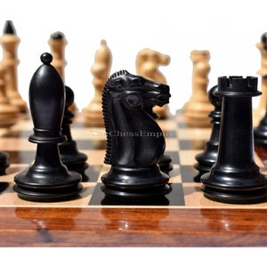 May include: Black and white chess pieces on a wooden chessboard. The black pieces are made of wood and have a glossy finish. The white pieces are made of wood and have a matte finish. The chessboard is made of wood and has a dark brown finish.
