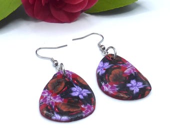 Pendientes colgantes triangulares con flores moradas, malvas, rojas y marrones, hechos de arcilla polimérica y acero inoxidable.
