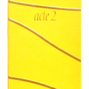 Puede incluir: Caja amarilla con letras doradas para una botella de Escada Act 2 Eau de Parfum. La caja tiene un diseño ondulado y el texto "Escada acte 2" y "Eau de Parfum" son visibles. La caja es de 50 ml.