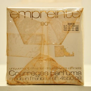 May include: A white box with gold lettering that reads "empreinte 90&deg;" and "Courreges parfums made in france - ref: 4550 08". The box also has a label with the text "4550 08 U.T.I.F. 294 ml Vol. id, cc. 400 Vol. an. cc. 360".