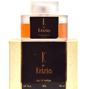 Può includere: Un flacone di profumo K de Krizia Eau de Parfum, con un liquido arancione chiaro. Il flacone è su una scatola con il nome del marchio in lettere dorate su sfondo marrone scuro. La scatola indica "1.69 Fl oz" e "50 ml 80".