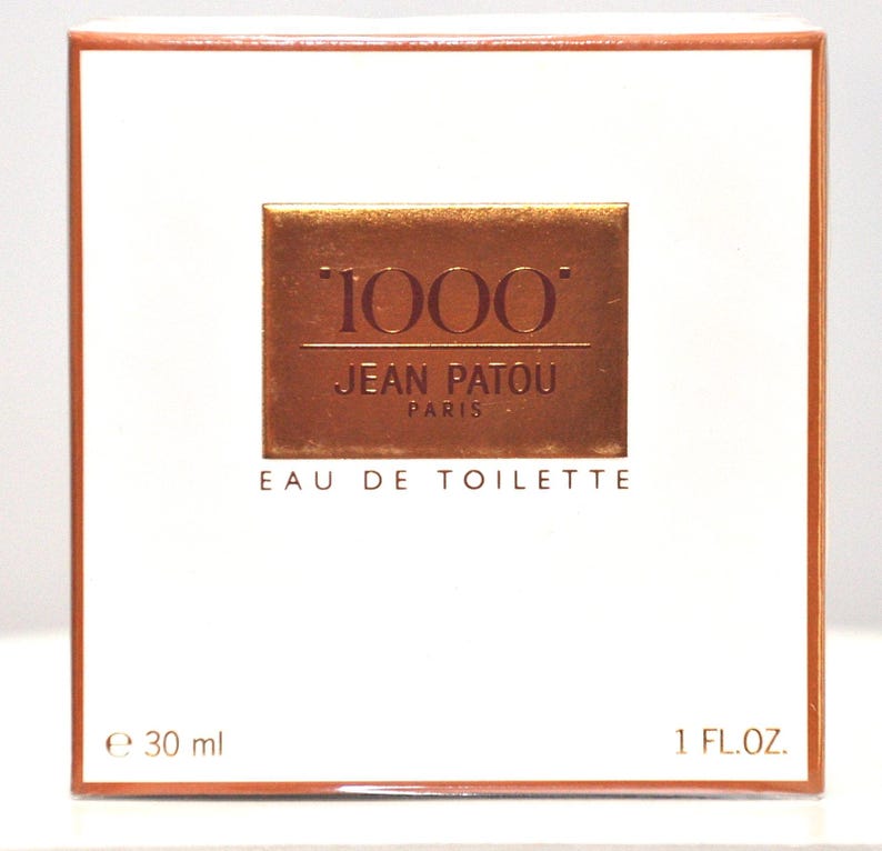 May include: A white box with a gold and red label that says "1000" Jean Patou Paris Eau de Toilette. The box is 1 fl oz or 30 ml.