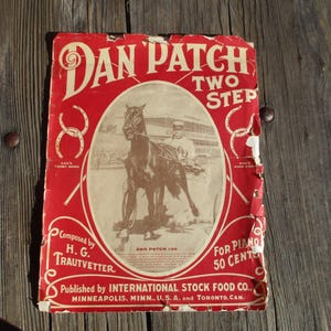 May include: A vintage sheet music cover for the song "Dan Patch Two Step" by H.G. Trautvetter. The cover features a black and white illustration of a horse and rider on a racetrack. The text "Dan Patch Two Step" is printed in red and white letters.