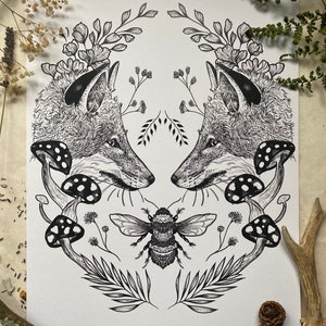 May include: Black and white illustration of two fox heads facing each other, surrounded by a wreath of flowers, leaves, and mushrooms. A bee is centered at the bottom of the illustration.