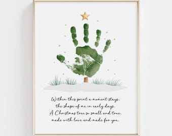 May include: Framed art print featuring a handprint Christmas tree design. The tree is green with a gold star on top. The print includes the text: "Within this print a moment stays...made with love and made for you."