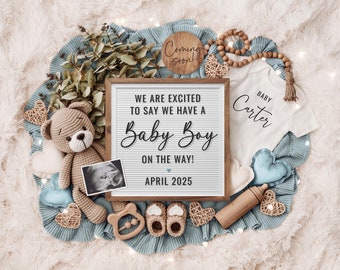 Puede incluir: Un anuncio de nacimiento con un tablero de letras blanco que dice "We are excited to say we have a Baby Boy on the way! April 2025". El tablero de letras está rodeado de una manta azul, un oso de peluche de crochet, un body de bebé que dice "Baby Carter", un sonajero de madera y un par de zapatitos de bebé.