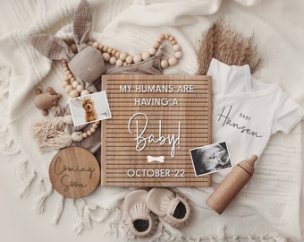 May include: A wooden sign with the text "My humans are having a baby! October 22" and a dog bone icon. There is a baby onesie with the text "Baby Hansen", a baby ultrasound image, a wooden baby bottle, and a wooden sign with the text "Coming Soon".